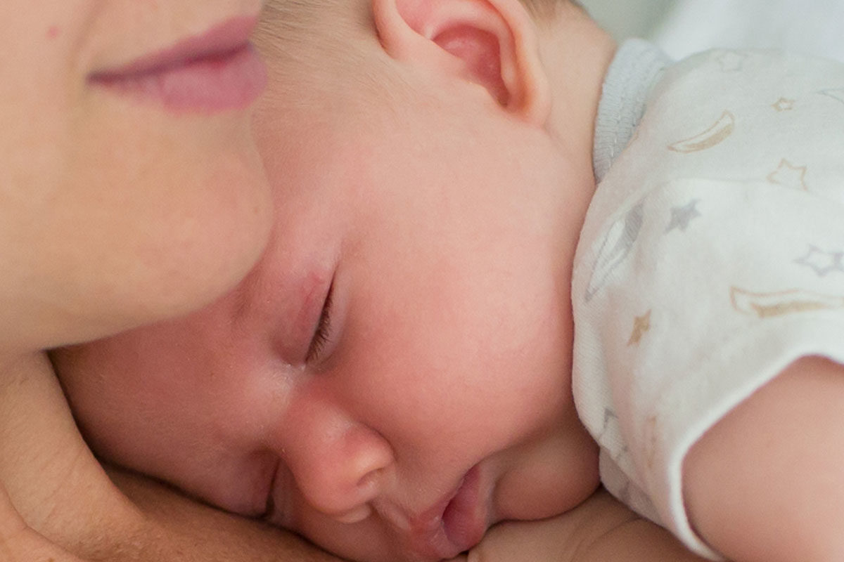 infant sleeping on women's chest