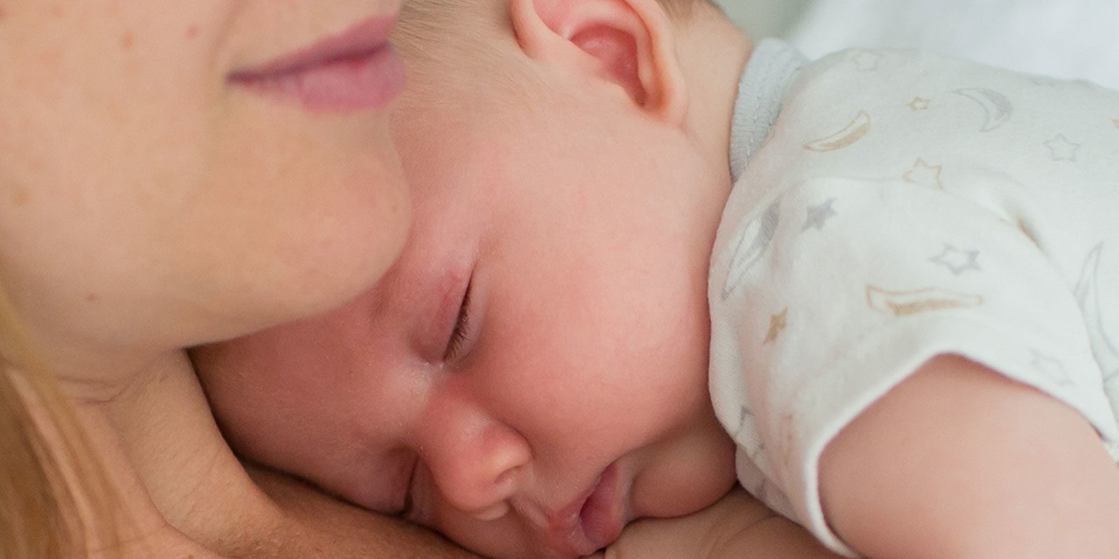 infant sleeping on women's chest