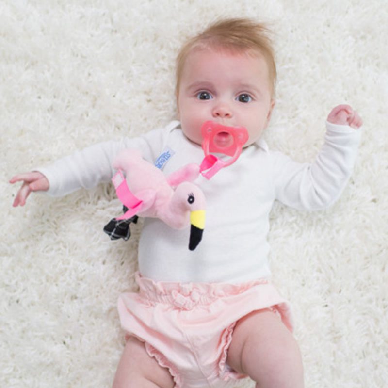 baby laying on rug with lovey pacifier