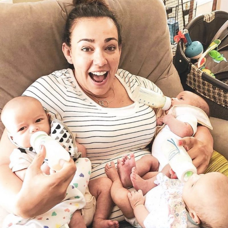 women holding and feeding triplets