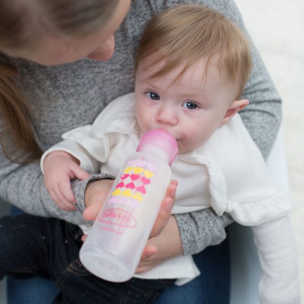 Dr Browns Sippy Bottle Starter Kit baby drinking on moms lap, Hearts and Pink.jpg