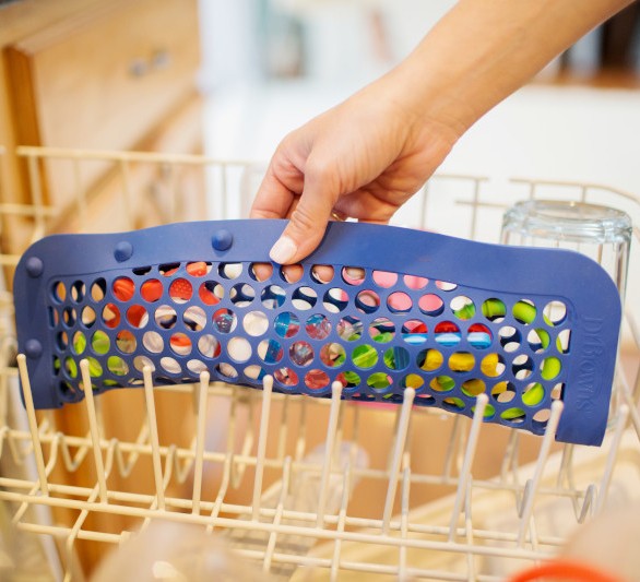 Woman's hand putting dishwasher bag into dishwasher folded in half lengthwise