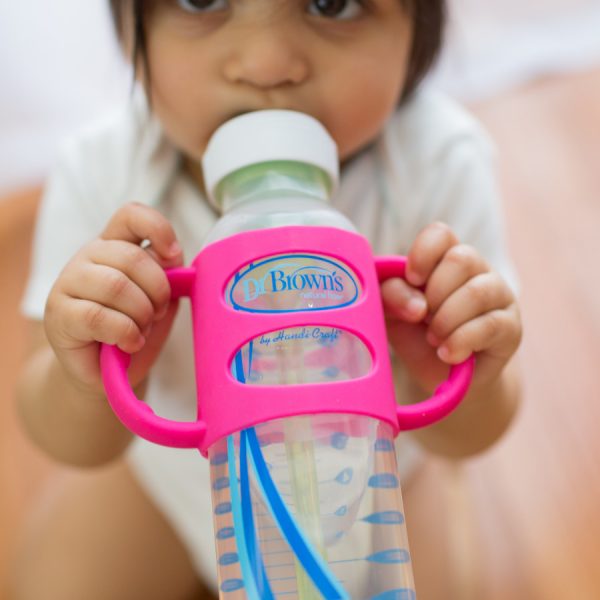 Baby drinking from bottle using silicone handles