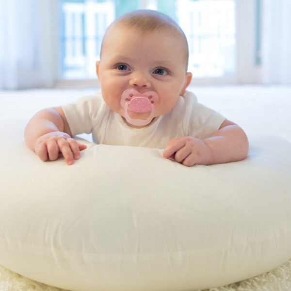 Baby with pink pacifier in mouth