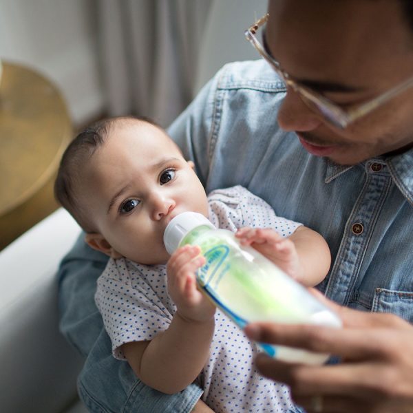 dad holding a baby drinking from a Dr. Brown’s Natural Flow® Options+™ Anti-colic GLASS Baby Bottle