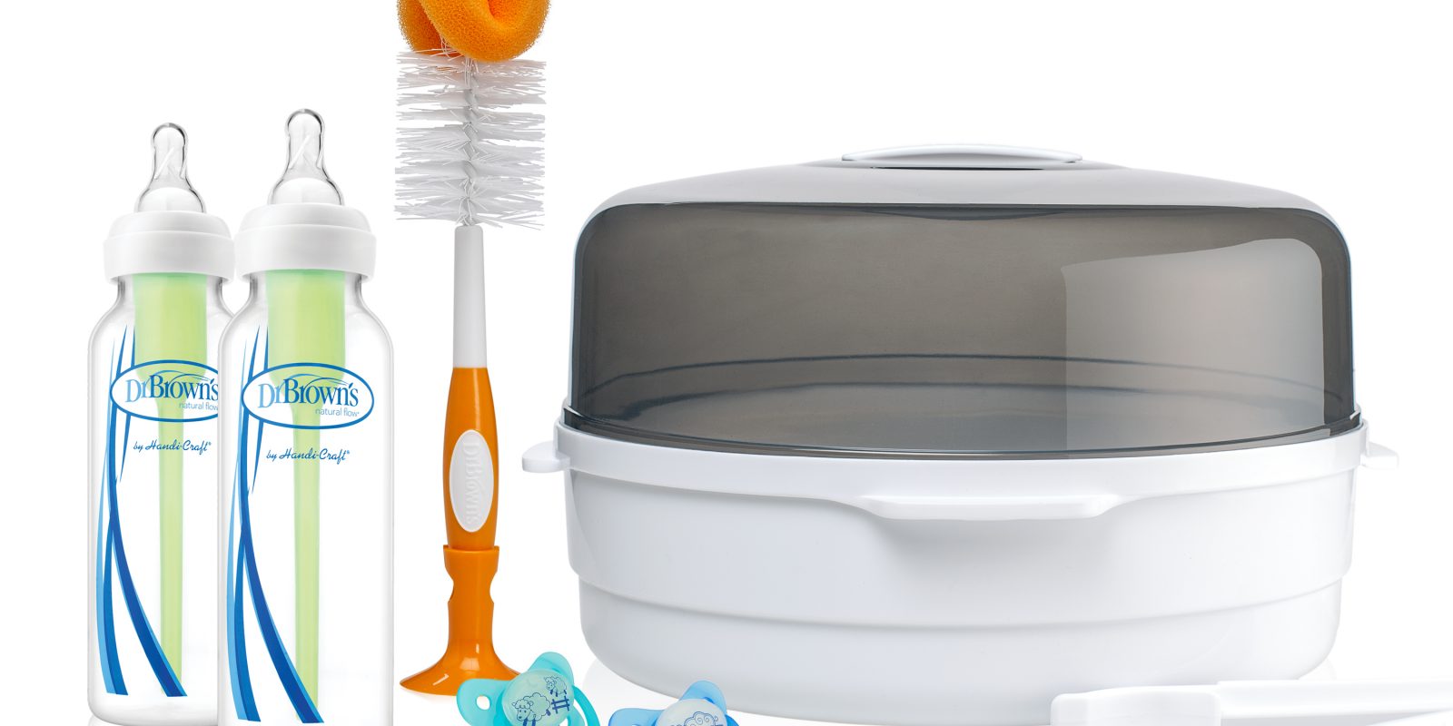 Microwave sterilizer next to bottle brush, pacifiers, and two bottles