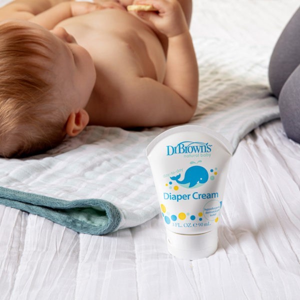 Dr. Brown's Diaper Cream on a bed with a baby