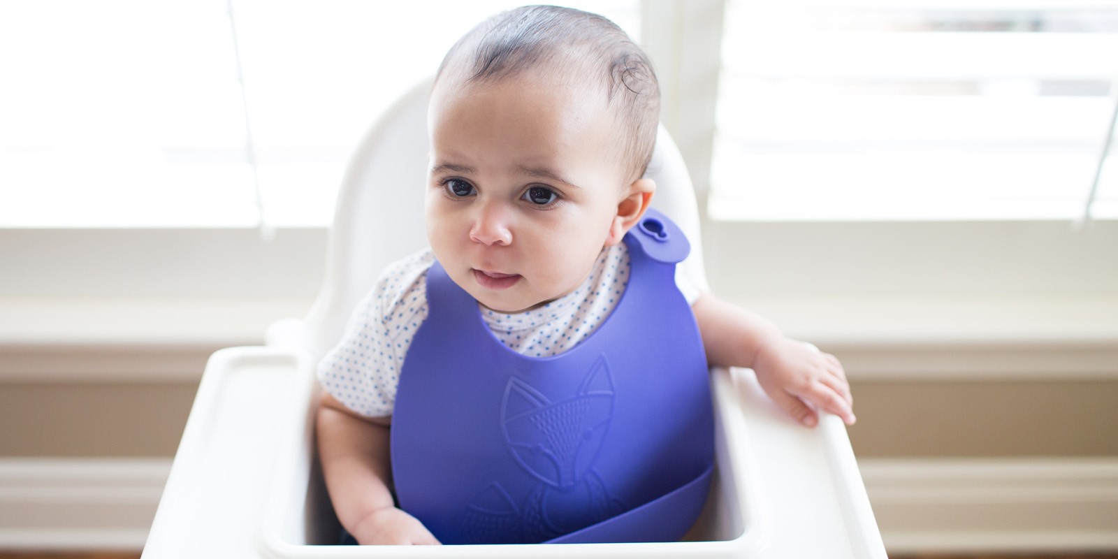 Toddler at high chair with silicone bib