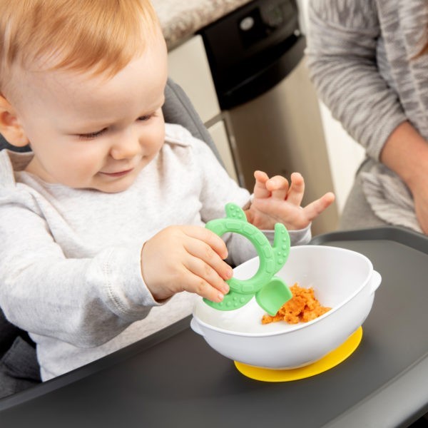 Baby eating from a Dr. Brown's Suction Bowl with a Dr. Brown's Silicone Starter Spoon green turtle
