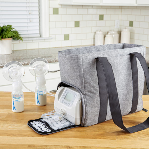 Gray pump bag on kitchen counter with pump zipper pocket open, collection kits with milk in bottle next to pump