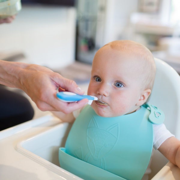 Mom feeding baby with White and Blue soft grip spoon