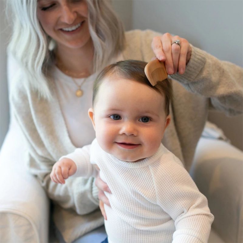 Parent brushing baby's hair