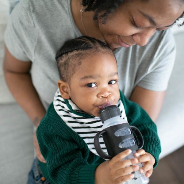 Parent with toddler holding a Black Milestones™ Narrow Sippy Bottle with Handles