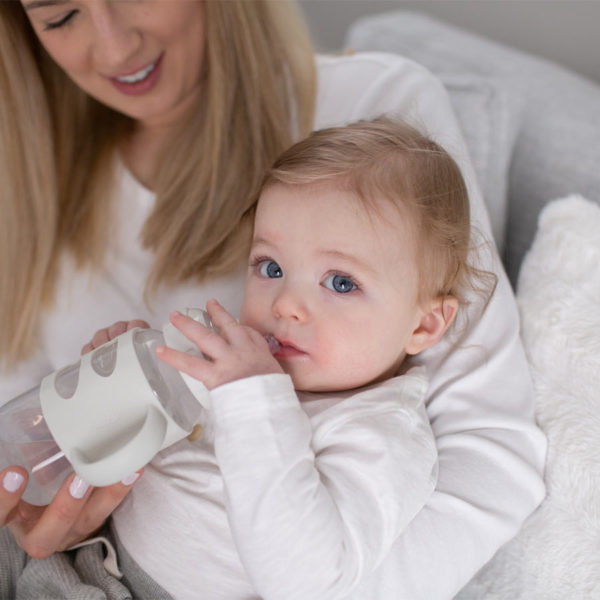 Parent with a toddler holding a Gray Milestones™ Wide-Neck Sippy Bottle with Silicone Handles
