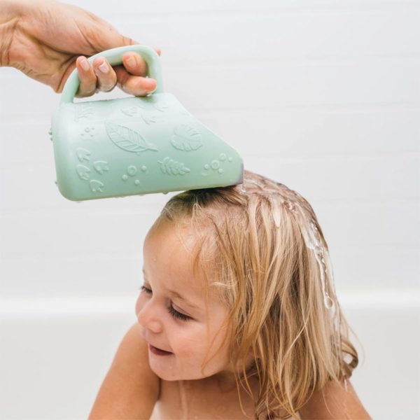 Toddler with rinse cup being poured on them