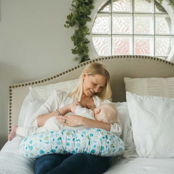 Parent feeding infant, using breastfeeding pillow