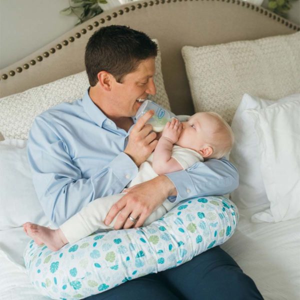 Parent feeding infant, using breastfeeding pillow
