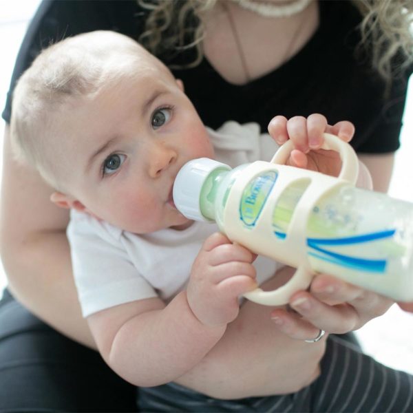 Parent holding a baby with a sippy bottle with ecru Narrow Silicone Handles
