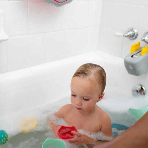 Toddler in bathtub with bath toys