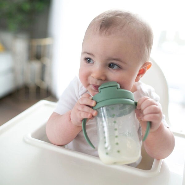 Infant holding an olive green straw cup