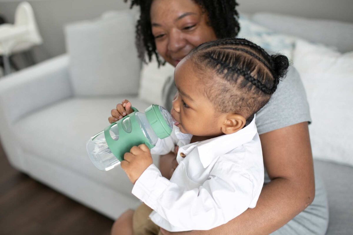 Parent and toddler with Green Sippy Bottle with Silicone Handles