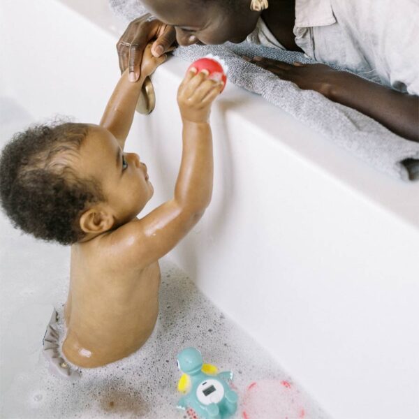 Parent and child with Temposaurus™ Floating Bath Thermometer in the tub