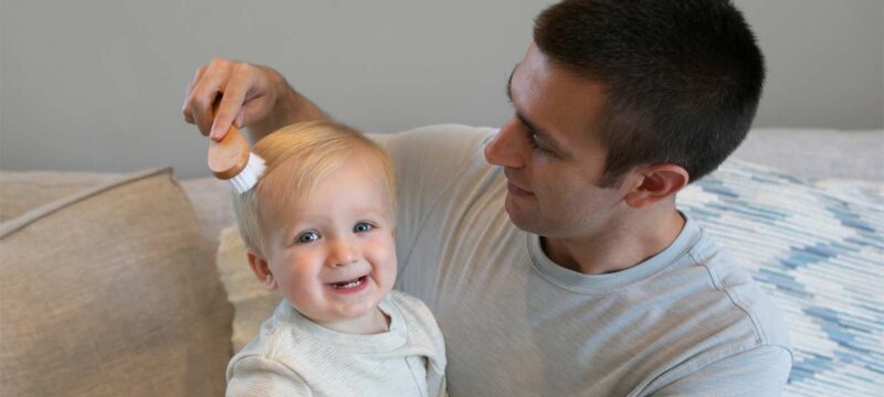 Parent brushing toddler's hair